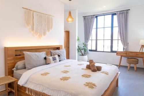 a bedroom with a bed with a teddy bear on it at Tropical Oasis Villa Private Pool Seseh beach in Seseh