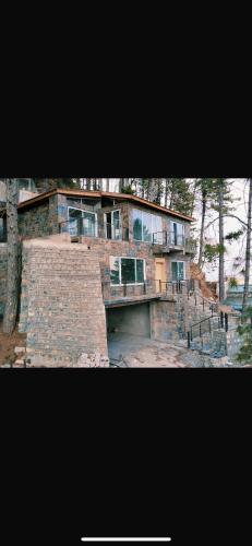 a large brick house with a staircase in front of it at Mushkpuri Terraces - Khaira Gali in Khaira Gali