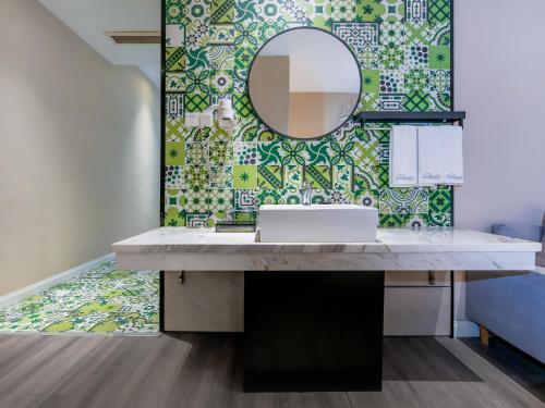 a bathroom with a sink and a mirror at 重庆莎霏酒店大渡口店 in Chongqing