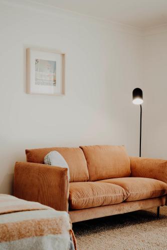 a brown couch sitting in a living room at The Cudgee at Mudgee in Mudgee