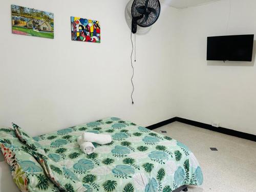 a bedroom with a bed with a clock on the wall at Casa Almanik Hostel in Medellín