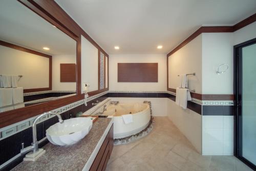 a bathroom with a large tub and a large mirror at Scenic Pool Villa and Resort in Ban Huai Yai