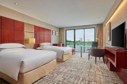 a hotel room with two beds and a flat screen tv at Hilton Guangzhou Science City, Free Shuttle Bus during Canton Fair in Guangzhou