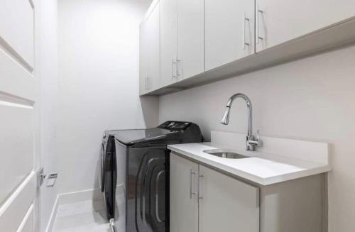 a kitchen with a washing machine and a sink at Uptown Dallas Modern Retreat in Dallas
