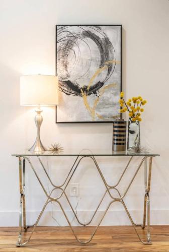 a table with a lamp and a picture on the wall at Uptown Dallas Modern Retreat in Dallas