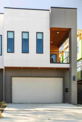 a white house with a garage door at Uptown Dallas Modern Retreat in Dallas