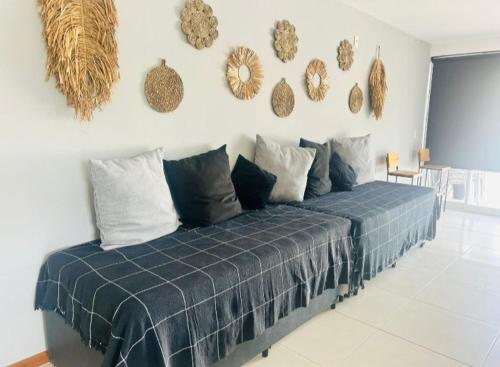 a bedroom with a bed with a blue plaid blanket at Apartamento Cobertura vista ao mar churrasqueira Prainha Arraial do Cabo in Arraial do Cabo