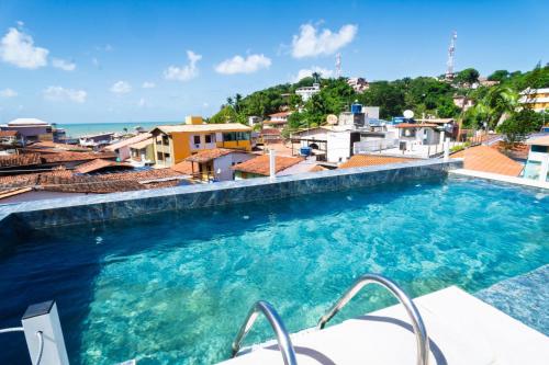 a swimming pool with a view of the ocean at Apartamento Mãe África Centro Morro de São Paulo in Morro de São Paulo