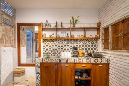 a kitchen with wooden cabinets and a tile wall at Villa Sare - House with panorama rice field view in Yogyakarta