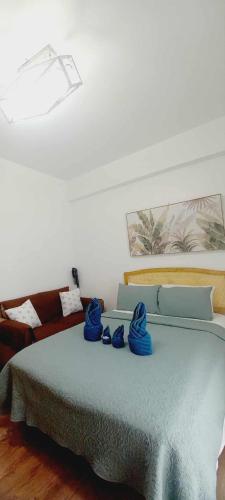 a bedroom with a bed with blue towels on it at Pool View Room 333B Amani Grand Resort near Mactan Cebu Airport Free wifi, netflix, pool and gym house, 3mins to airport in Pusok