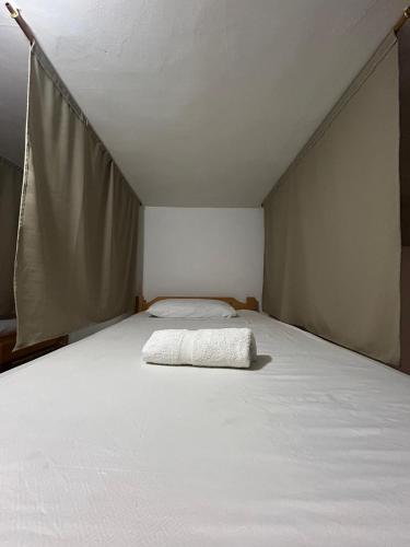 a large white bed in a small room at Casa Almanik Hostel in Medellín