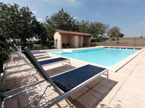 une piscine avec deux chaises longues à côté dans l'établissement Maison périgourdine avec piscine, cheminée, Wifi, parking, animaux admis - FR-1-616-75, à Daglan