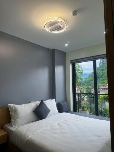 a bedroom with a bed and a large window at Sky Hotel & Homestay Ha Giang in Ha Giang