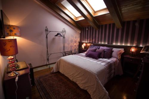 a bedroom with a bed with purple pillows at Hotel Dei Pittori in Turin
