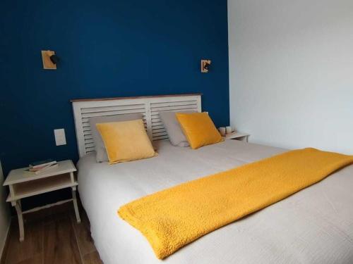 Charmant gîte avec terrasse à La Barre-de-Monts - FR-1-426-586 في لا باريه دي مونت: غرفة نوم بها سرير ووسادتين صفراوين