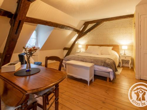 une chambre avec un lit et une table dans une pièce dans l'établissement Chambres d'hôtes spacieuses près de la Loire - FR-1-622-116, à La Menitré