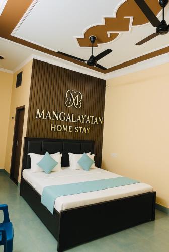 a bedroom with a bed with a sign on the wall at Mangalayatan Home Stay Ayodhya in Faizābād