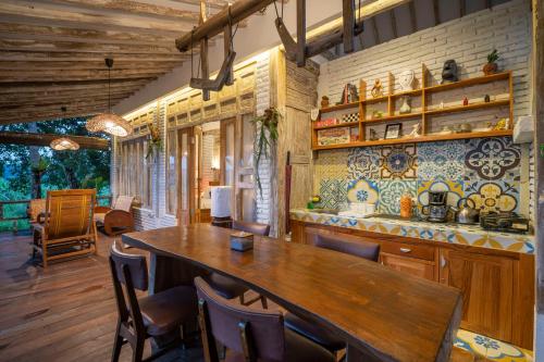 a kitchen with a large wooden table and chairs at Villa Sare - House with panorama rice field view in Yogyakarta