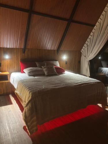 a bedroom with a large bed in a wooden room at Paraíso da Harmonia in Teutônia