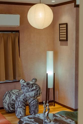 a living room with a bed and a lamp at 箱根 星那 箱根中心 神社 海賊船徒歩圏 in Hakone