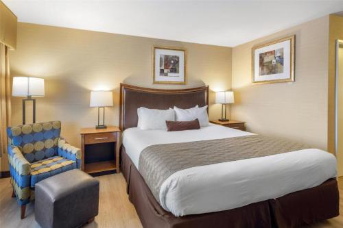 a hotel room with a large bed and a chair at Best Western Inn Santa Clara in Santa Clara