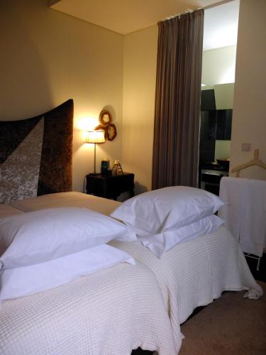 a bedroom with two beds with white pillows at Family Secrets Douro in Riba Douro
