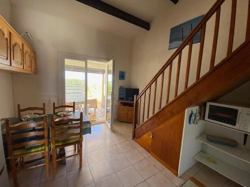 une cuisine et une salle à manger avec une table et un escalier dans l'établissement Villa T3 Mezzanine, 6 pers., Accès plage, Parking, Animaux admis - FR-1-798-39, à Leucate