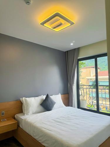a bedroom with a bed and a large window at Sky Hotel & Homestay Ha Giang in Ha Giang