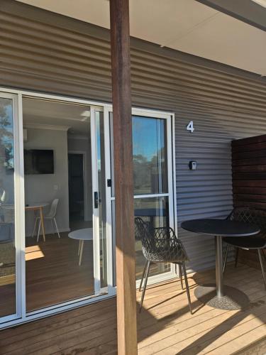 a patio with a table and chairs on a deck at Parndana Hotel Cabins in Parndana