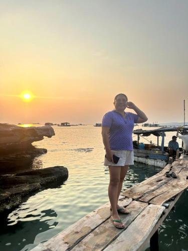 a woman standing on a dock in the water at Happy House Gành Dầu in Phu Quoc