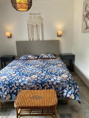 a bedroom with a bed with a blue and white comforter at LOUE CHAMBRE CHEZ L HABITANT ACCES A LA CUISINE A 10 MN DES PLAGES in PloÃ©ven