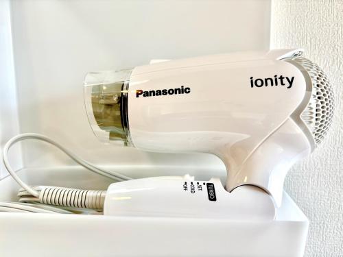 a white hair dryer sitting in a shelf at 古民家ｓｔｙｌｅ富山駅東 in Toyama