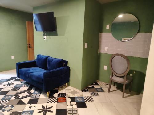 a living room with a blue couch and a chair at Suite Reforma in Oaxaca City