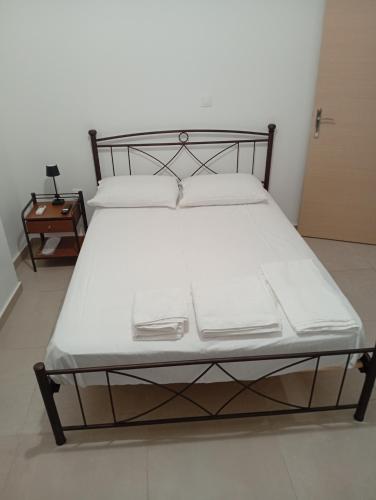 a bed with white sheets and pillows in a room at Tournis in Chios
