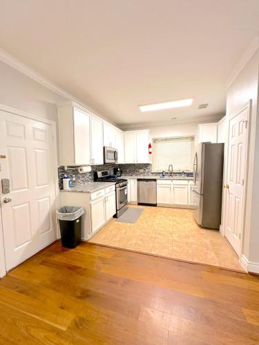 a kitchen with white cabinets and a stainless steel refrigerator at Spacious 5bed Houston Retreat Home in Houston