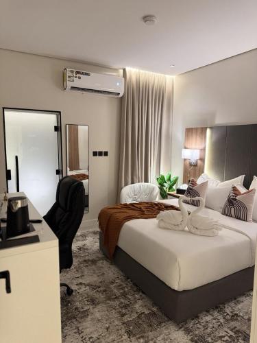 a bedroom with a bed and a desk and a chair at Marvin Suites in Al Wajh