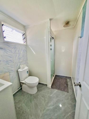 a bathroom with a toilet and a glass shower at Nuku'alofa Town Cottage - Entire Place Upstairs Only in Nuku‘alofa