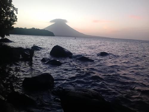 a mountain in the distance with rocks in the water at Eco lodge finca magdalena in Altagracia