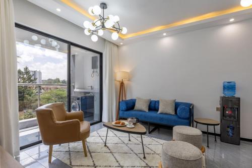 a living room with a blue couch and chairs at Nandwa Ivy By YourHost, Kileleshwa, Nairobi in Nairobi