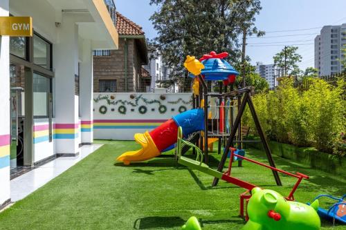 a playground with a slide on the grass at Nandwa Ivy By YourHost, Kileleshwa, Nairobi in Nairobi