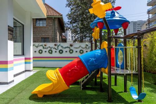a playground with a slide in a yard at Nandwa Ivy By YourHost, Kileleshwa, Nairobi in Nairobi