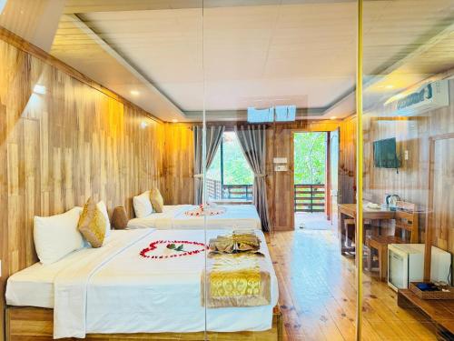a hotel room with two beds and a table at Ong Lang Garden Resort in Phu Quoc
