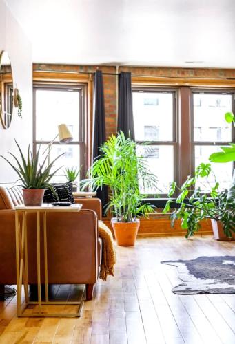 a living room with potted plants and a couch at Jungle House Luxury Homes - Columbus Downtown Short North - Walk to Convention Center & Nationwide Arena - Sleeps up to 10 - Free Parking - Over 5,800 Five Stars in Columbus