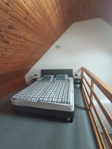 a bed in a room with a wooden ceiling at HamvasDomb Vendégház in Egerszalók