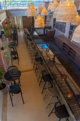 a long bar with chairs and tables and chandeliers at Senoma Hotel - Adults only in Ica
