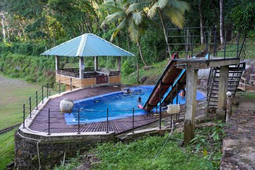 une petite piscine avec un toboggan et un toboggan dans l'établissement Tappers' Village Nature Resort & Retreat Centre, Kiriella, à Ratnapura