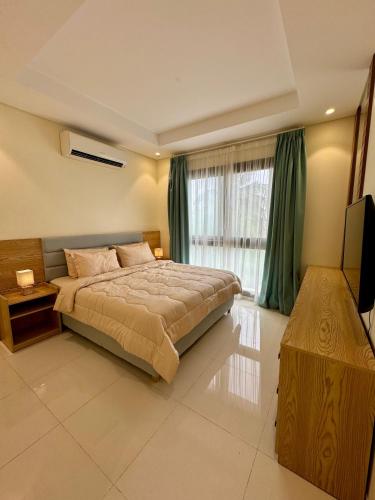 a bedroom with a large bed and a television at هوانا ڤيو - Hawana view in Ma‘mūrah