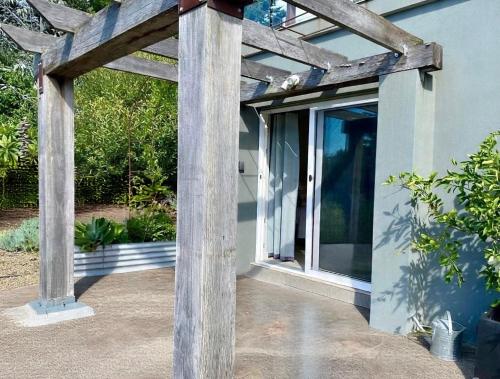 a wooden pergola on the side of a house at Hills View BnB Studio Kiama Heights in Kiama
