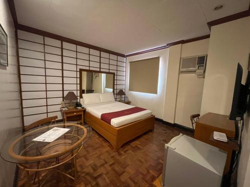 a small room with a bed and a table at AMALFI718 HOTEL in Lipa