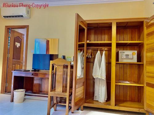 a room with a wooden closet with a desk at Don Bosco Hotel School in Sihanoukville
